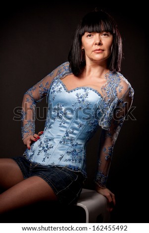Closeup portrait of sexy woman in blue corset with embroidery