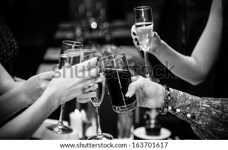 Black and white  photo of people holding glasses of wine and clinking