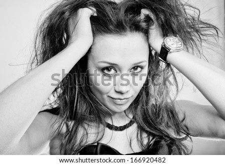 Black and white portrait of woman holding hands on curly hair