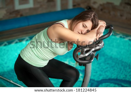 Portrait of brunette woman relaxing after training on exercise bike