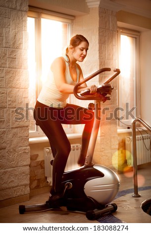 Indoor photo of woman riding trainer bike at fitness club