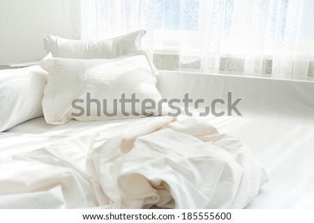 Horizontal photo of untidy bed against window
