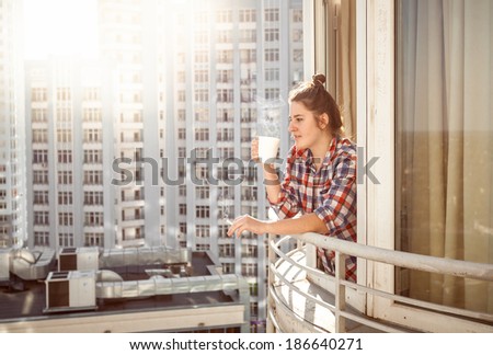Portrait woman drinking coffee and smoking out of window