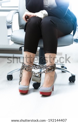 Photo of businesswomen legs being locked by chain