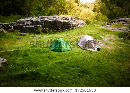 Landscape of beautiful hills with two tourist tents at sunny day