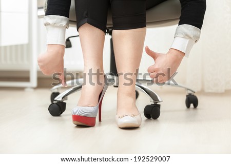 Closeup photo of woman wearing high heel shoe and ballet flat holding thumbs down and up