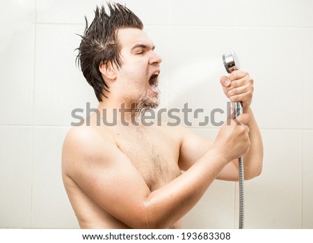 Portrait of funny man singing at shower