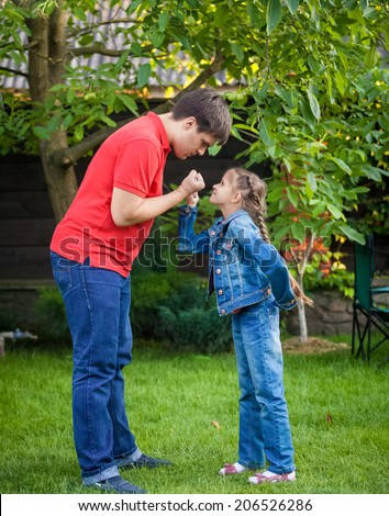 Young angry father and daughter looking at each other and holding fists