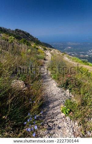 View of long gravel path on high mountain at sunny day