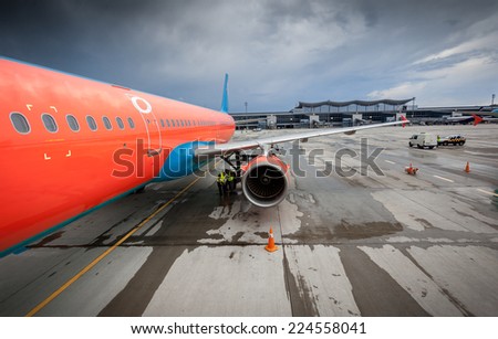 Big civilian airliner with jet engine on runway at storm