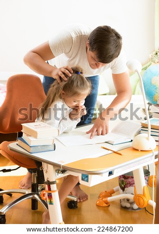 Young father angry at daughter doing homework