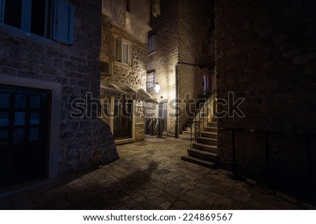 Beautiful narrow street of ancient city illuminated by lantern at night