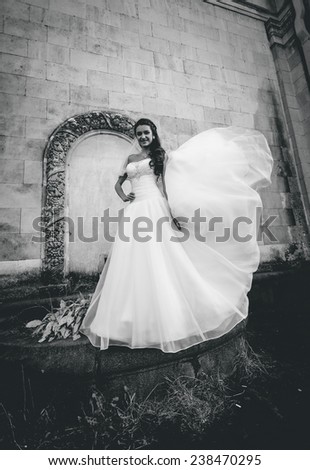 Black and white photo of wind lifting up brides veil at old castle
