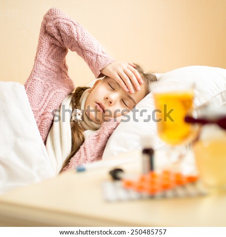 Portrait of sick girl lying in bed and holding hand on head
