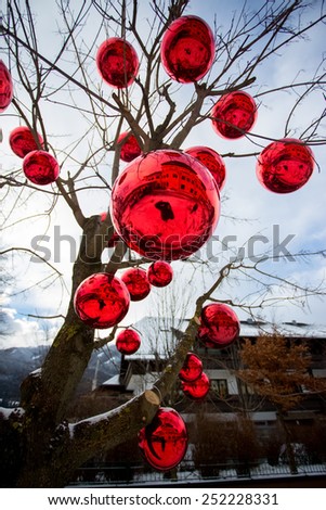 Closeup photo of tree on street decorated with big red balls