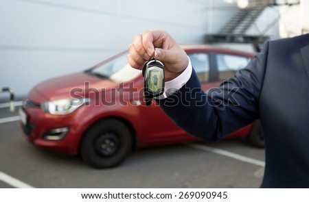 Closeup shot of man in suit showing car keys with alarm remote control