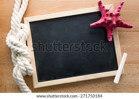 Horizontal shot of clean blackboard decorated by marine knot and starfish