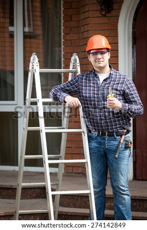 Portrait of happy worker on building site holding thumbs up