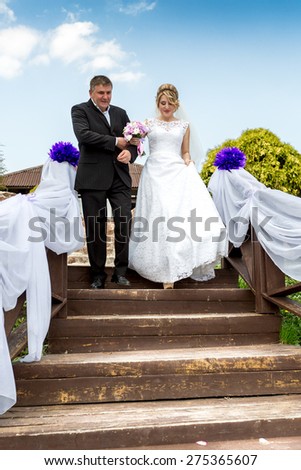 Father leading happy smiling bride to wedding altar down the stairs
