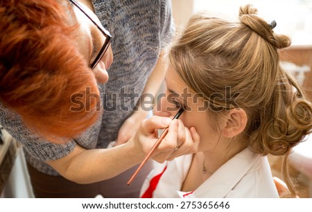 Closeup portrait of makeup artist applying bridal makeup