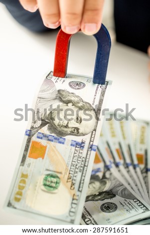 Conceptual photo of official stealing money with use of magnet