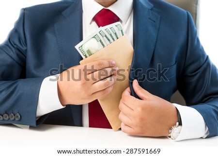 Closeup conceptual photo of bribed man putting money in the suit pocket