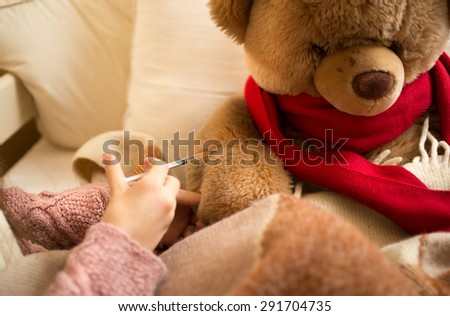 Closeup photo of little girl doing injection to sick teddy bear