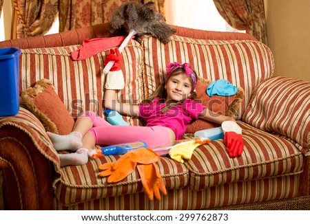 Funny photo of exhausted girl relaxing on sofa after cleaning house