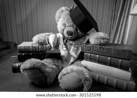 Black and white photo of teddy bear in graduation hat sitting on table