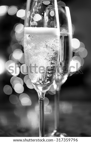 Macro black and white photo of champagne poured into glasses