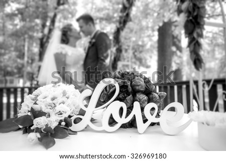 Black and white closeup photo of word Love on table at wedding ceremony