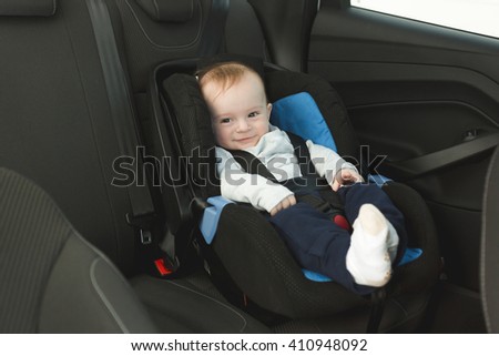 Cute 6 months old baby in car child seat