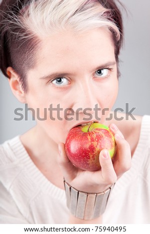 Young beautiful lady holding and biting red apple