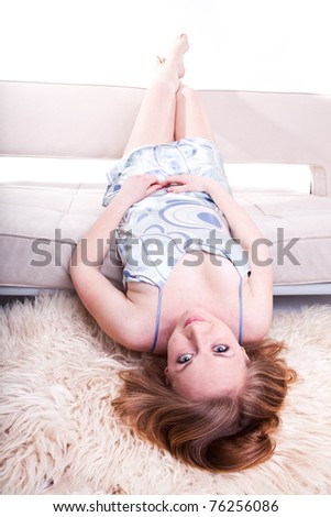 Young beautiful woman is lying in the sofa
