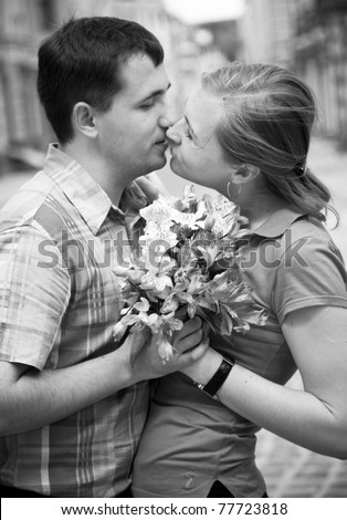 Black and white portrait of two young person kissing