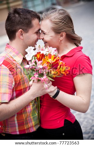Portrait of two young person holding bunch of flowers and smiling