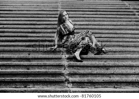 black and white photo of woman sitting on steps