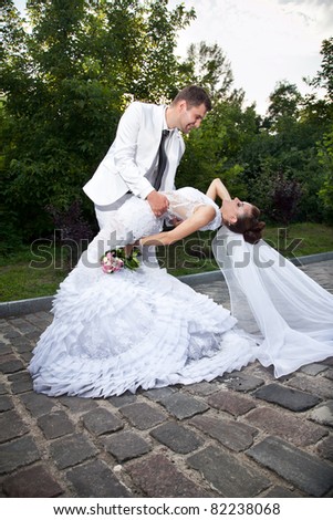 Newly married couple dancing in park