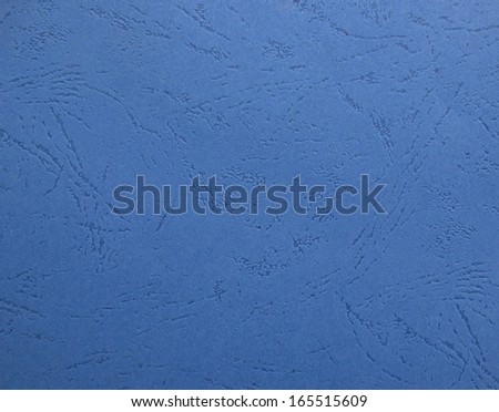 Close-up of a blue textured cardboard with engraved patterns.