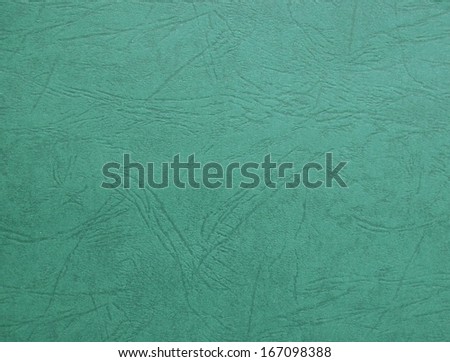 Close-up of a green textured cardboard with engraved patterns.