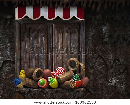 Various fake cupcakes, candy, doughnuts, and ice cream cones decoration on wooden window ledge.