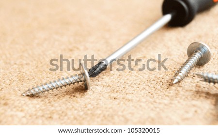 Screw-driver and screws on a fabric.