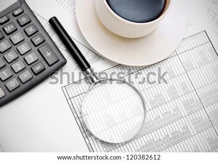 Calculator, coffee, magnifier on documents.