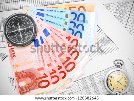 Compasses, money and watch on documents.
