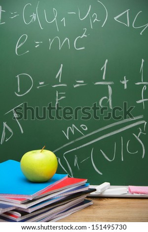 Apple and writing-books against a school board with mathematical formulas.