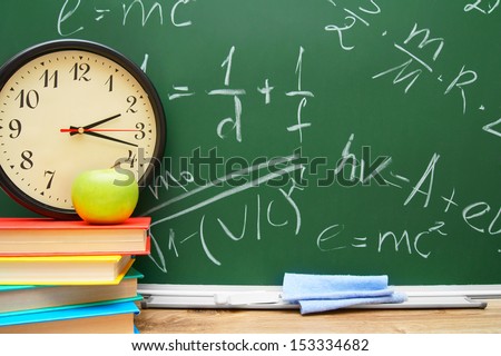 Watch and an apple on books. Against a school board with formulas on the physicist.