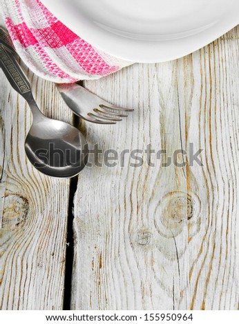 Dining facilities and plate. On wooden board.