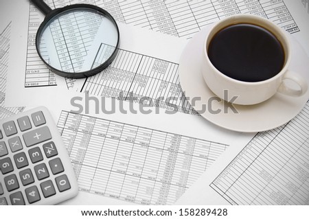 Coffee, the calculator and magnifier on documents.