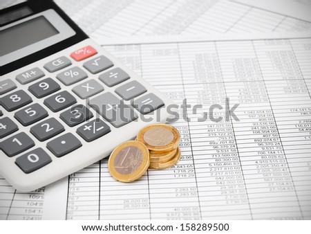 Calculator and coins on the documents