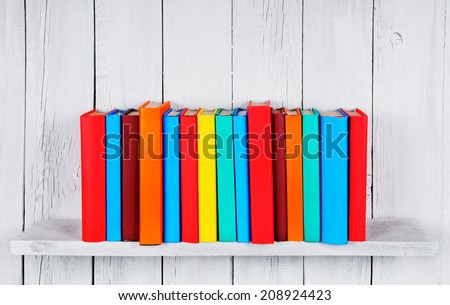 Books on a wooden shelf. On a wooden, white background.